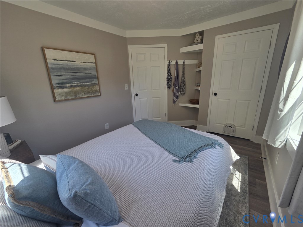 Neutral-toned walls paired with wood-finish flooring, featuring dual paneled interior doors and built-in corner shelving