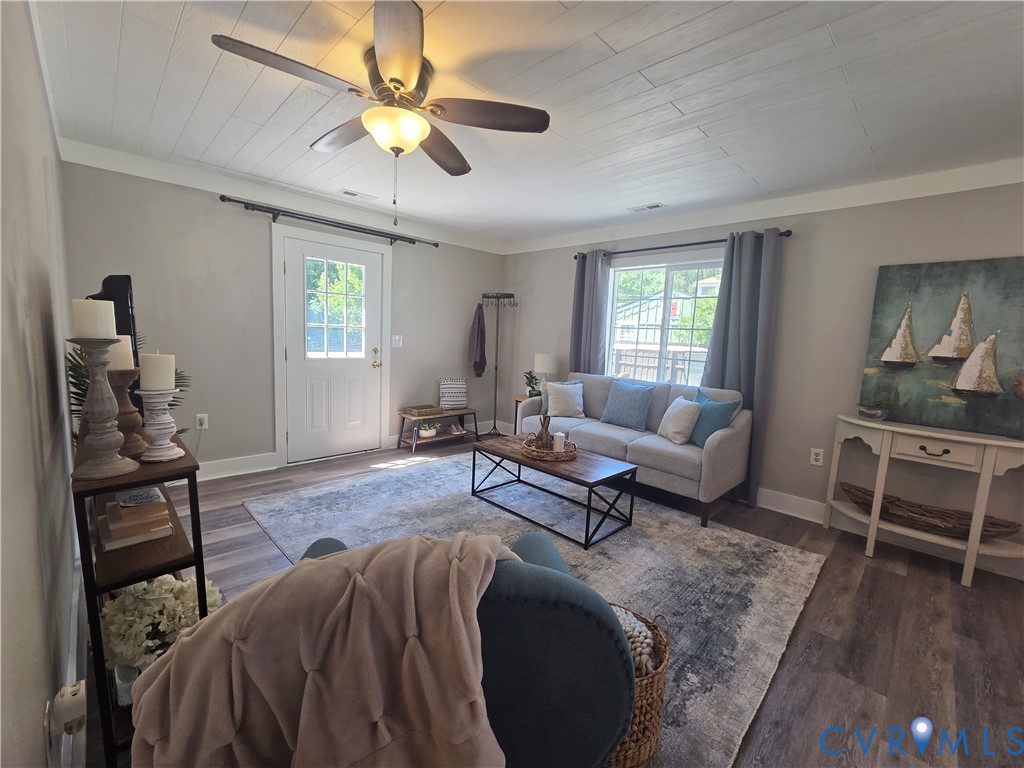 Wood-finish flooring, white plank-style ceiling, and central ceiling fan with integrated light fixture