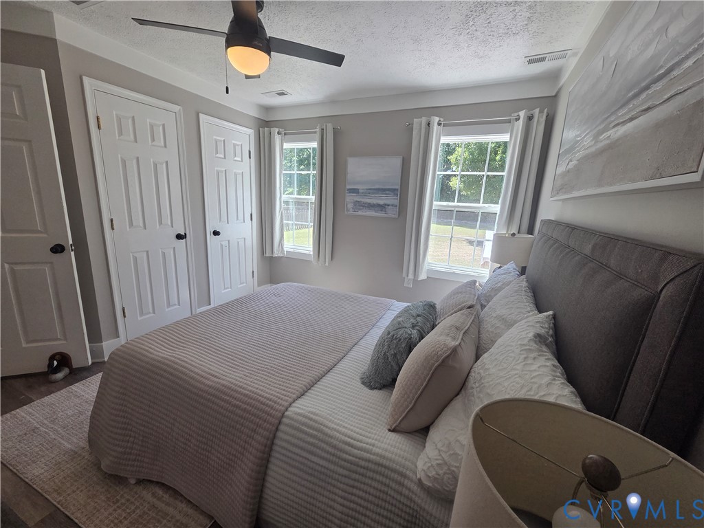 Interior space featuring dual windows with grid detailing, multi-panel interior doors, and a ceiling fan with integrated lighting