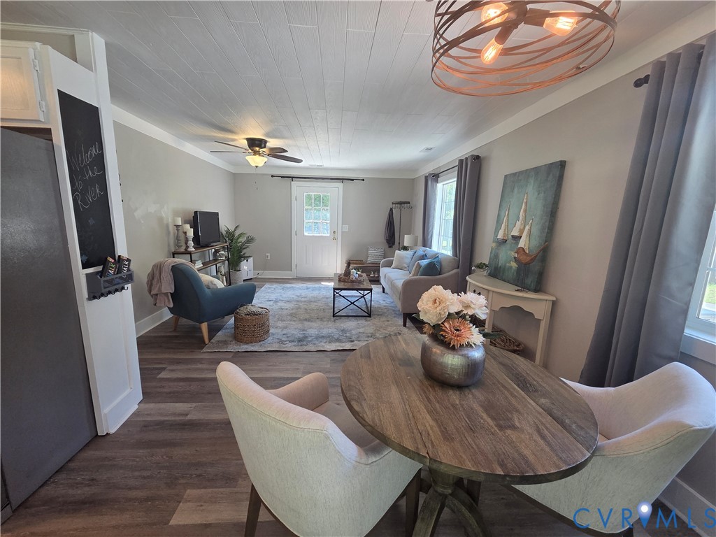 Plank-style wood-finish flooring, white shiplap ceiling, circular bronze-tone cage pendant lighting, and a built-in chalkboard panel