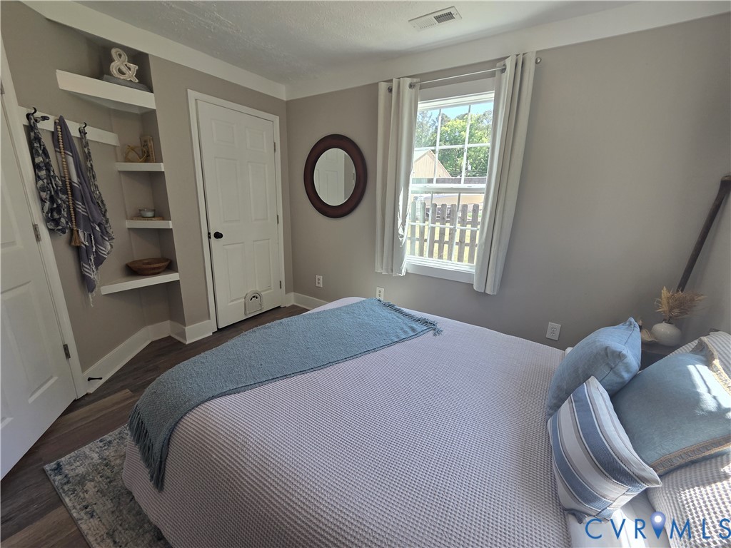 Built-in corner shelving, wood-finish flooring, and a single-pane window with a multi-light sash design