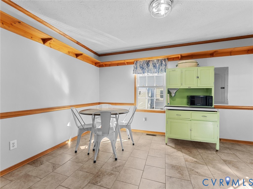 Tile flooring, natural wood chair rail, upper wood wall shelving, and a built-in cabinet