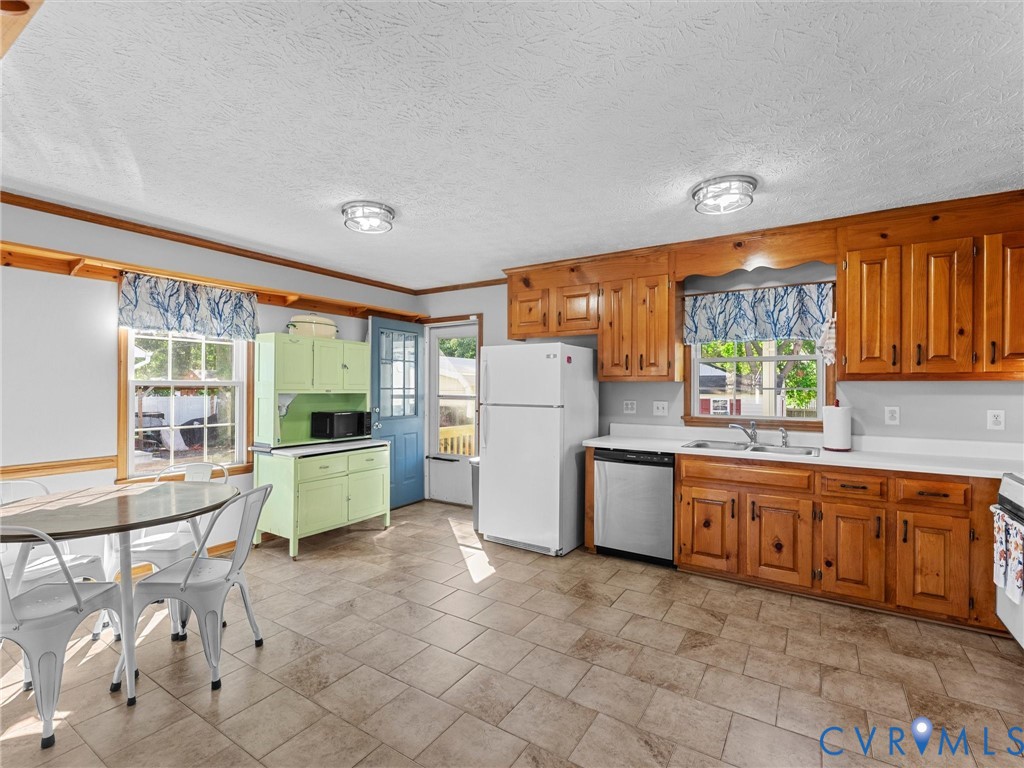 Kitchen featuring natural wood cabinetry, tile flooring, built-in lower cabinetry with an integrated hutch, stainless steel dishwasher, and dual-basin sink with a gooseneck faucet
