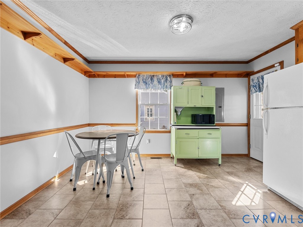 Tile flooring, natural wood crown molding, chair rail trim, and built-in wall shelving