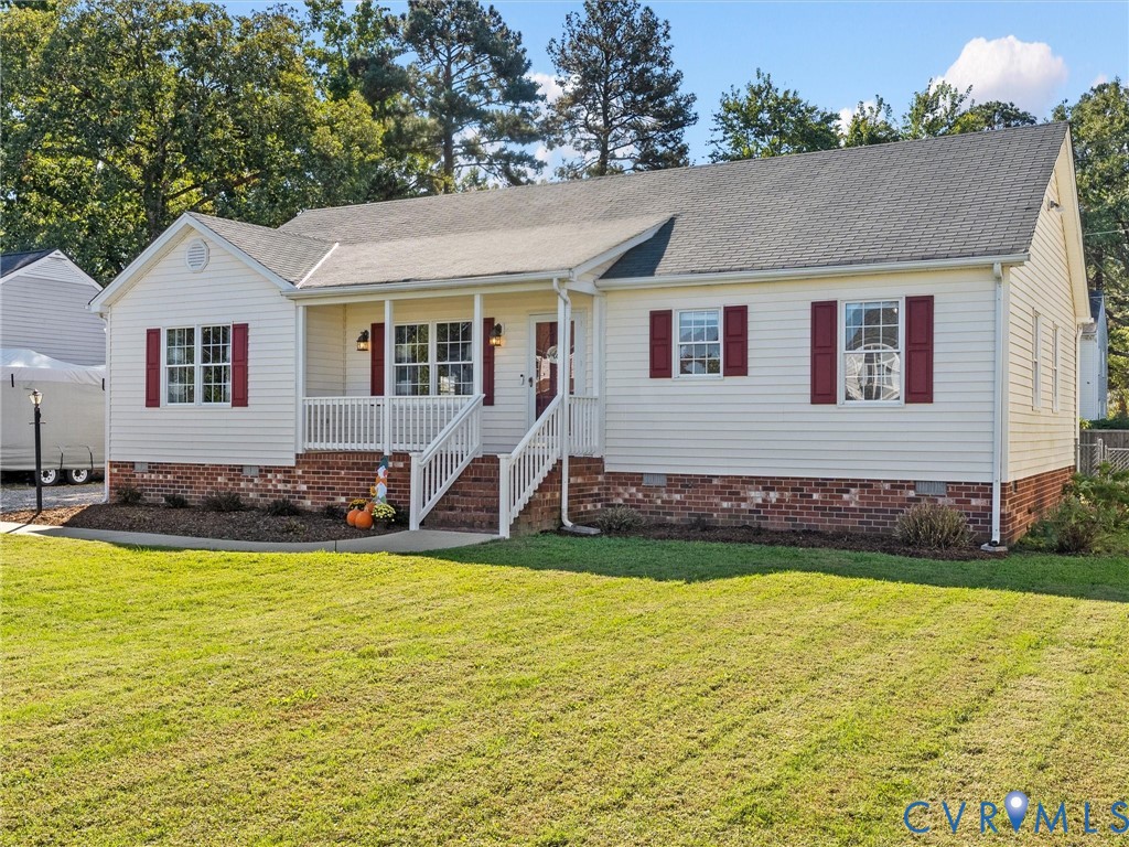 Single-story residence featuring horizontal siding, a red brick veneer foundation, contrasting window shutters, and a covered front porch with white railing