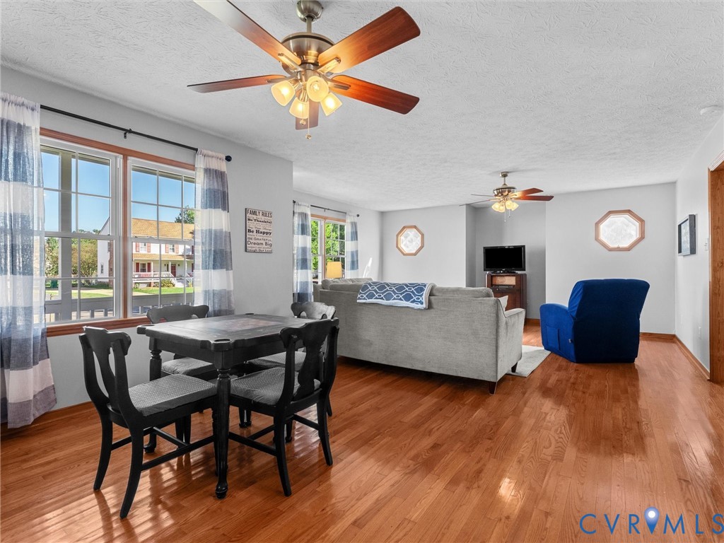 Wood-finish flooring, dual ceiling fans with integrated light fixtures, and octagonal accent windows