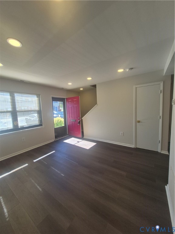 Interior space featuring dark wood-finish flooring, recessed lighting, and a multi-pane window