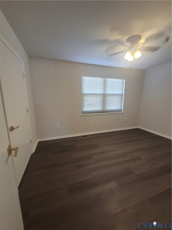 Room featuring wood-finish flooring, a multi-light ceiling fan, and a neutral color palette