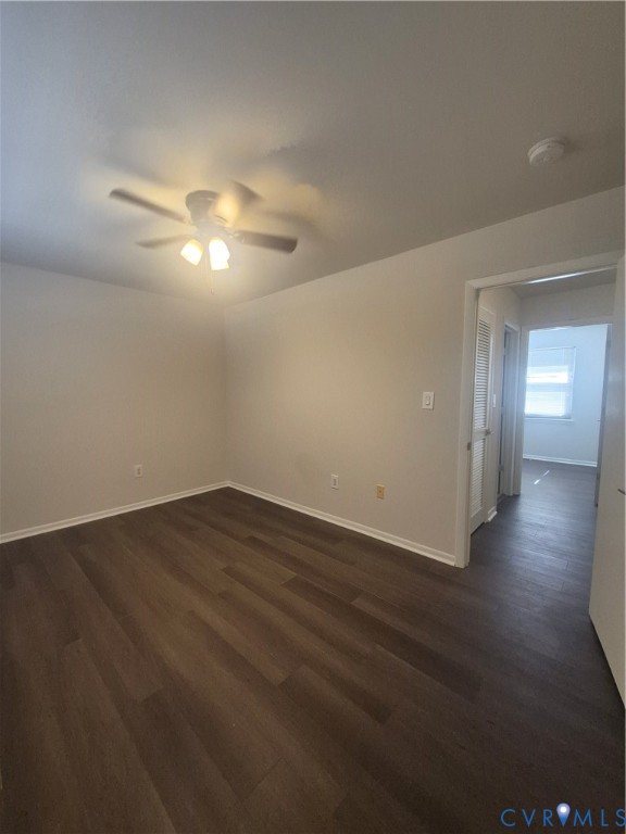 Neutral interior featuring wood-finish flooring, a ceiling fan with integrated lighting, and louvered closet doors
