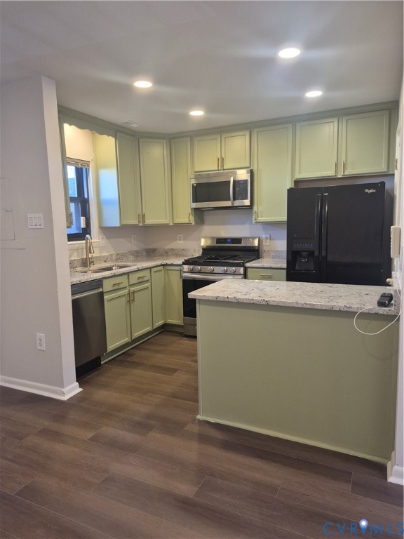Kitchen featuring shaker-style cabinetry, stone countertops, wood-finish flooring, recessed lighting, and stainless steel appliances
