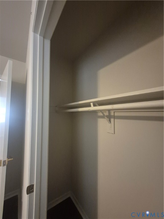 Reach-in closet featuring a built-in shelving unit, integrated garment rod, and neutral wall finish