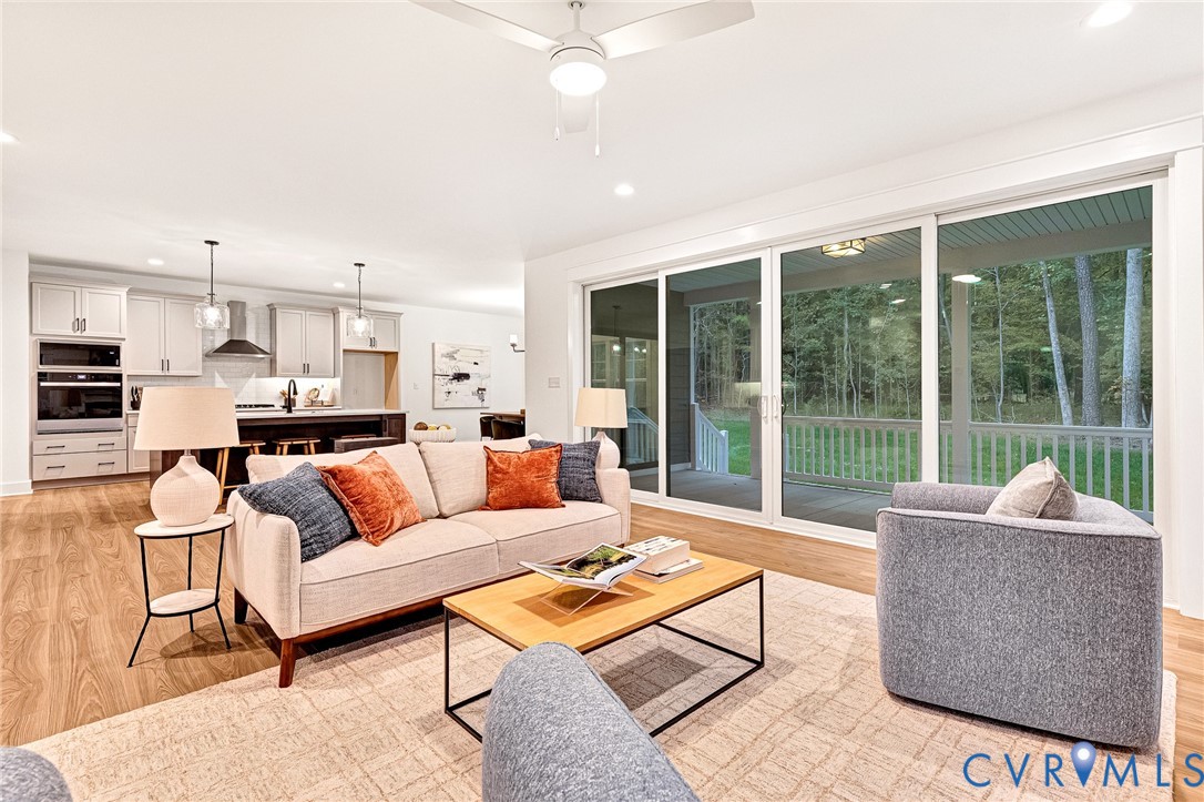 Open-concept living space featuring wood-finish flooring, recessed lighting, and a modern ceiling fan