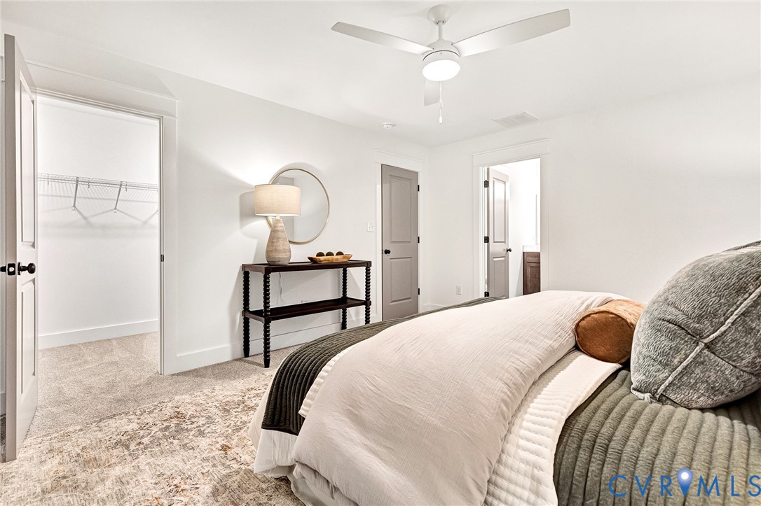 Neutral-toned carpeting, white walls, integrated ceiling fan with light kit, and interior doors with matte black hardware