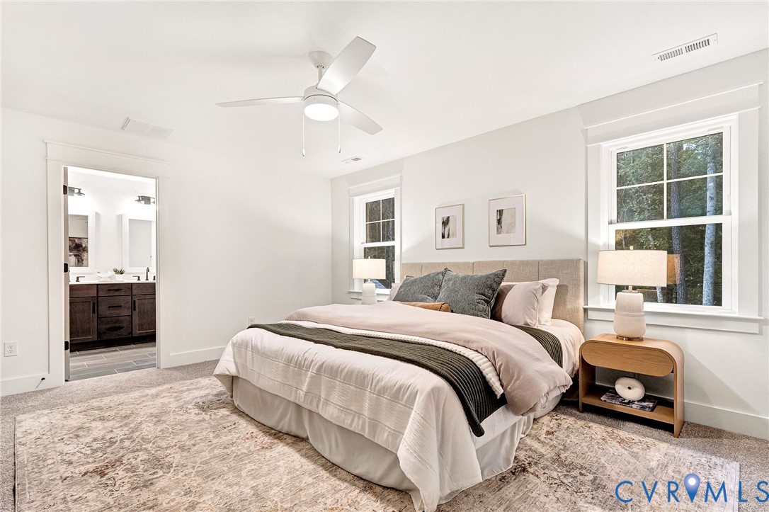 Neutral-toned bedroom featuring crisp wall trim, multi-pane windows, and an integrated ceiling fan with light fixture
