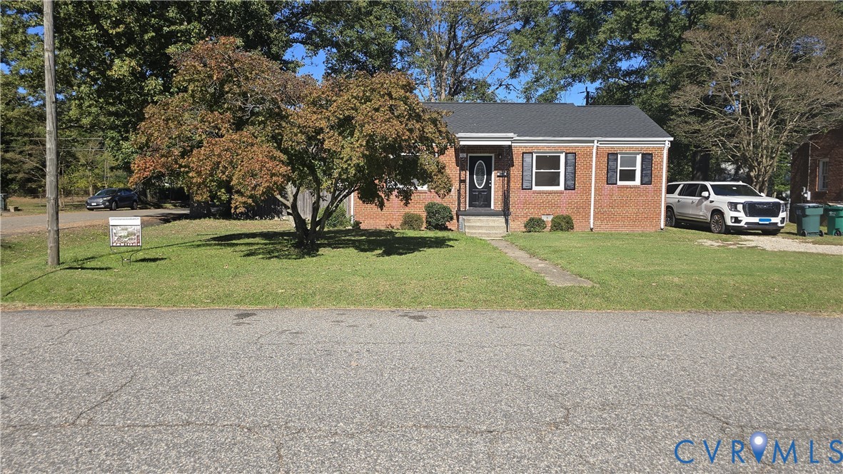Single-story brick exterior featuring a dark shingle roof, decorative exterior shutters, and a covered front entry Single-story brick exterior featuring a dark shingle roof, decorative exterior shutters, and a covered front entry
