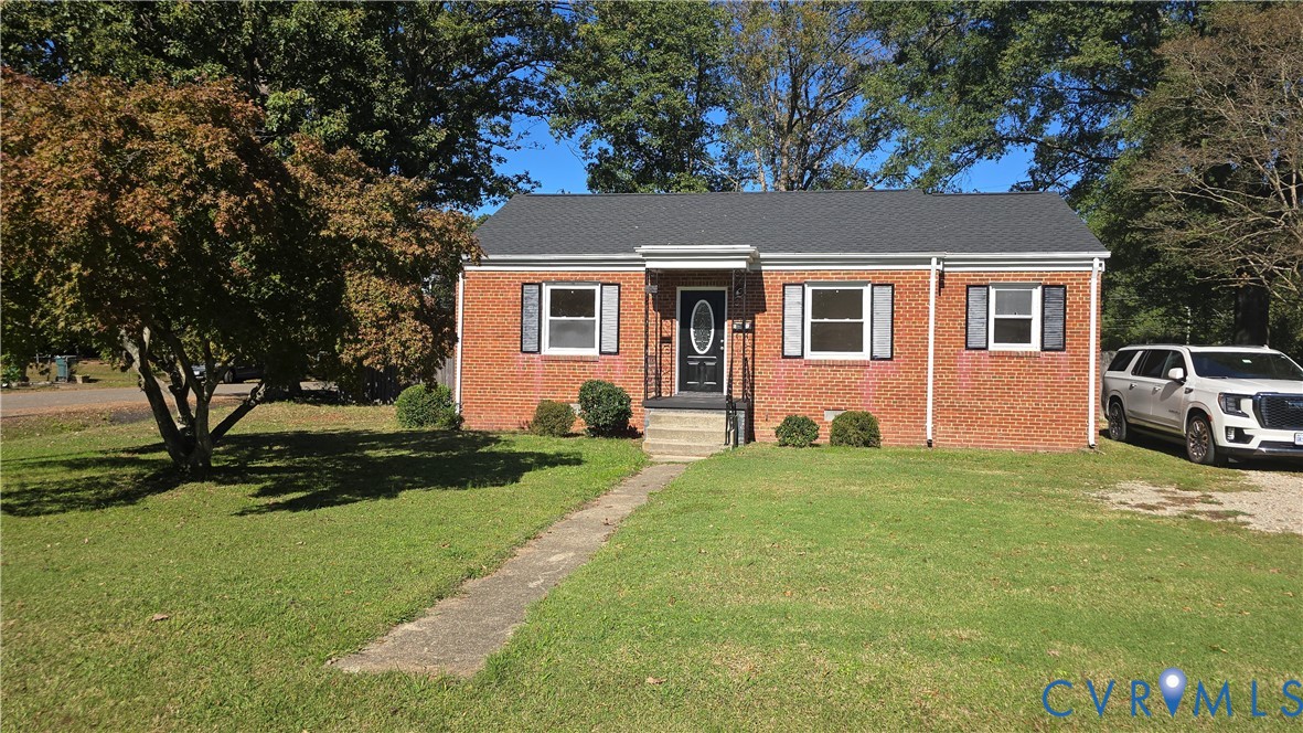 Single-story brick exterior featuring a shingled gable roof, shuttered windows, and a covered front entry Single-story brick exterior featuring a shingled gable roof, shuttered windows, and a covered front entry