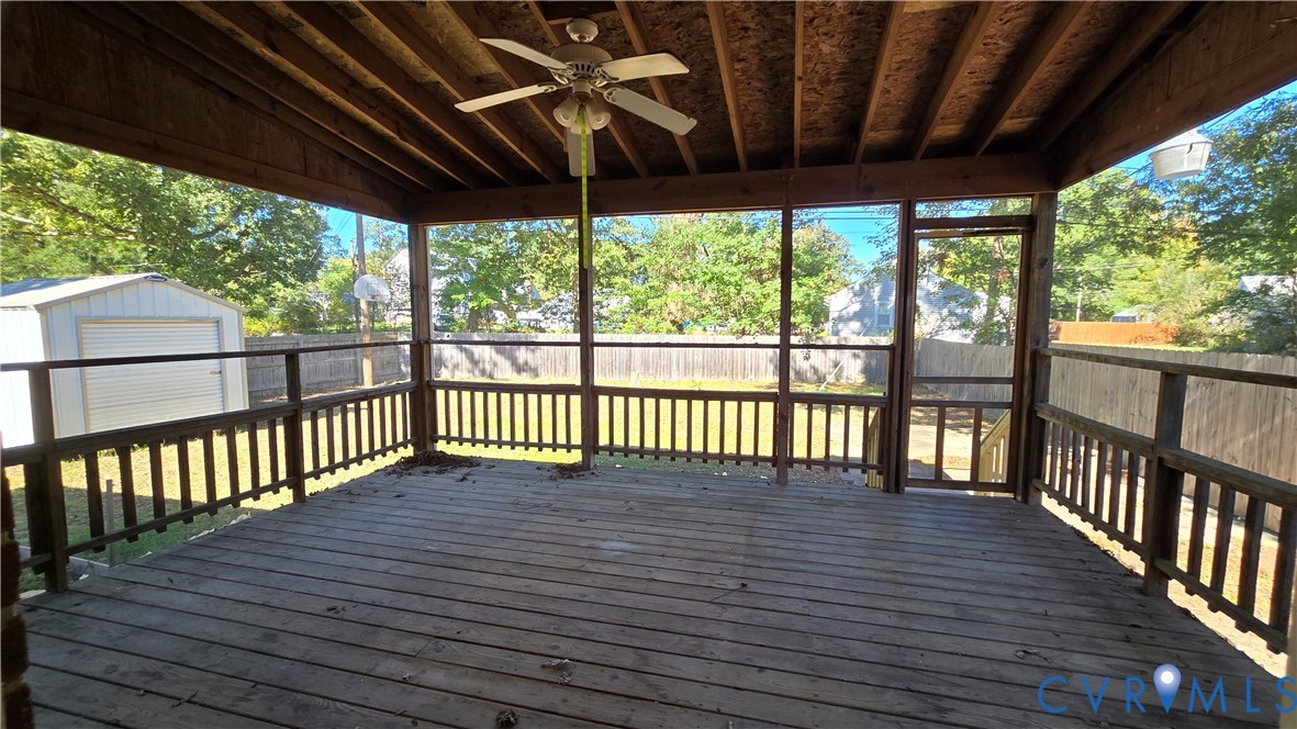 Covered deck featuring exposed wood rafters, a ceiling fan, wood-plank flooring, and perimeter railing