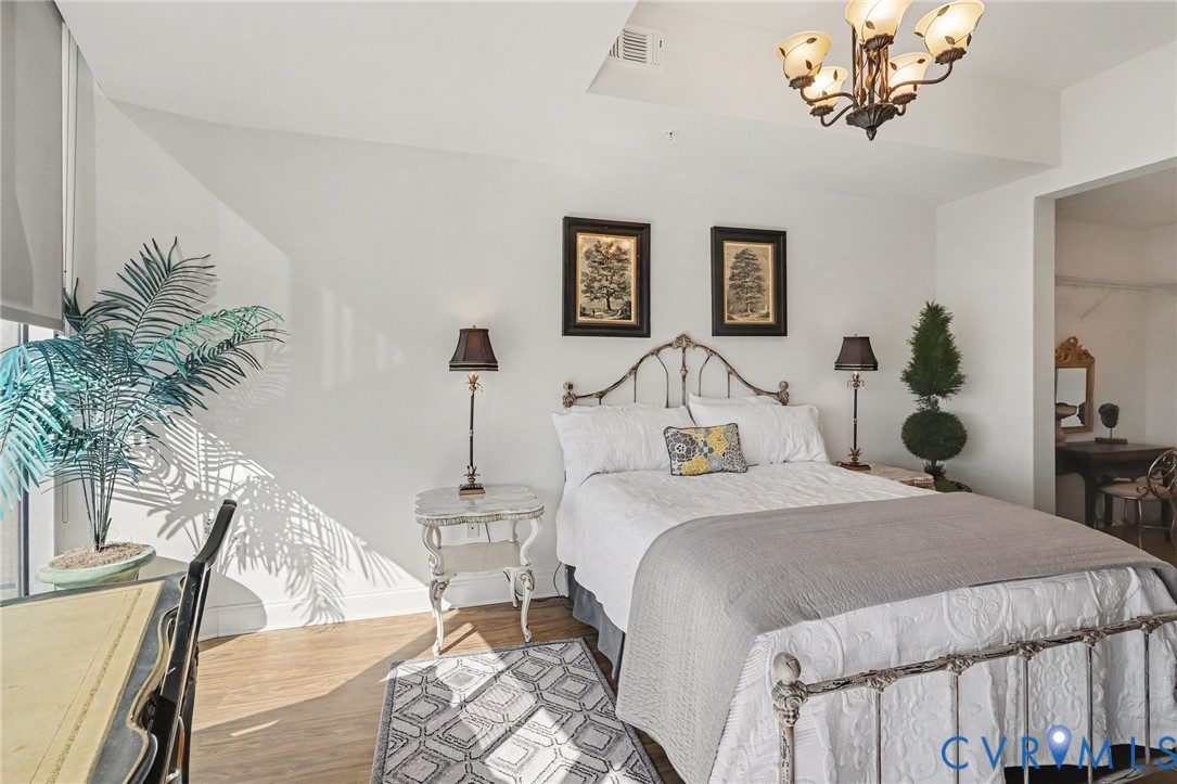 Wood-finish flooring, high ceilings, and a decorative multi-arm chandelier