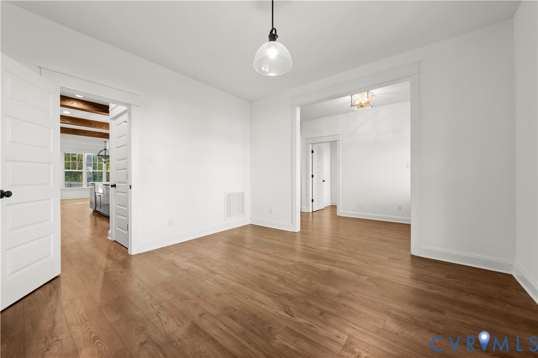 Interior space featuring wood-finish flooring, a glass pendant light fixture, and classic white paneled doors