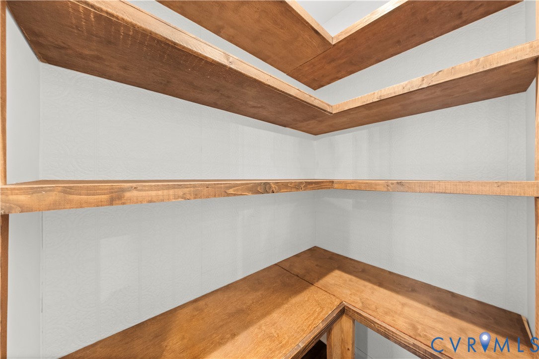 Built-in corner shelving featuring stained wood-finish surfaces and neutral wall paneling