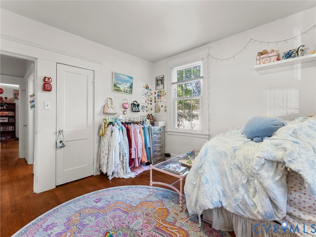 Wood-finish flooring, white-painted interior walls, single-hung window with casing, and a two-panel interior door