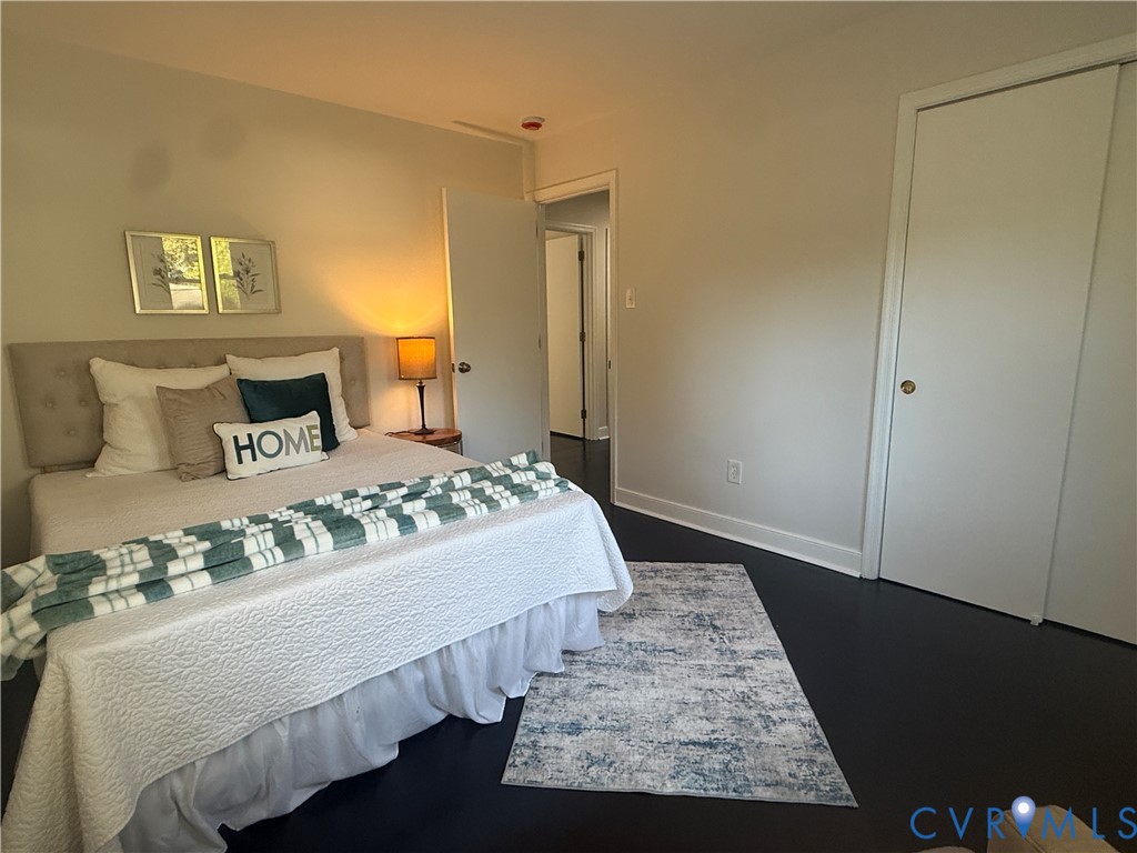 Room featuring dark wood-finish flooring, neutral wall paint, and a built-in sliding-door closet