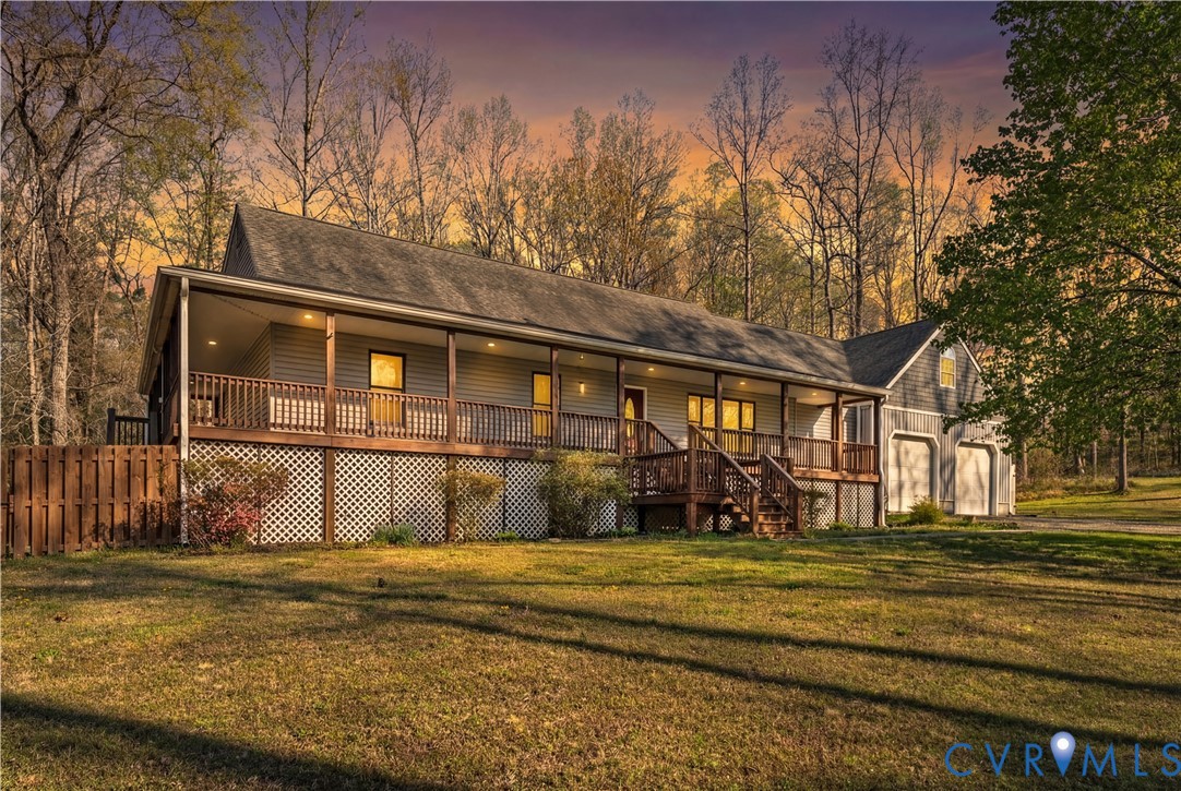 Ranch-style residence featuring a full-length covered porch, attached two-car garage, lattice skirting, and horizontal siding Ranch-style residence featuring a full-length covered porch, attached two-car garage, lattice skirting, and horizontal siding