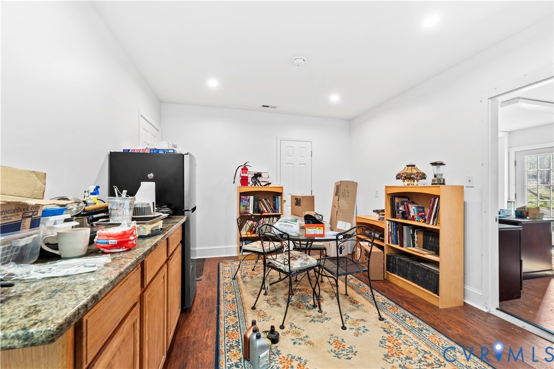 Kitchen area featuring wood-finish cabinetry, stone-texture countertops, and wood-finish flooring