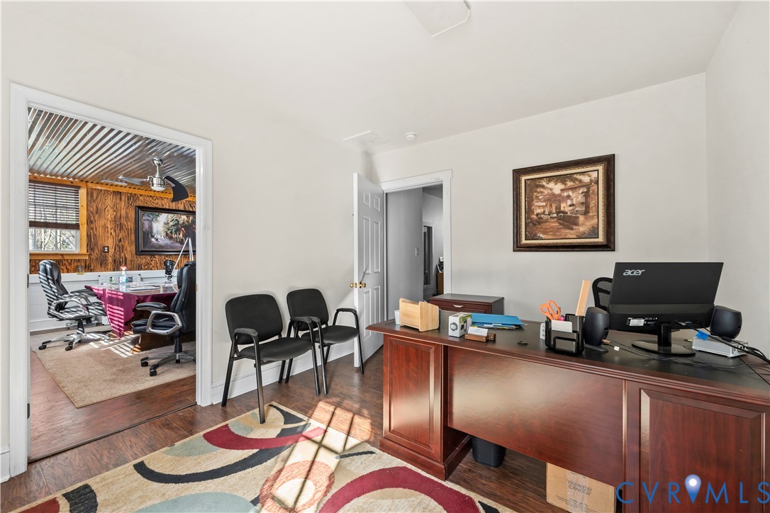 Room interior featuring wood-finish flooring, white walls, and interior doorways