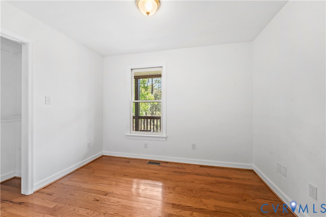 Wood-finish flooring, neutral walls, flush-mount ceiling lighting, and single-hung window