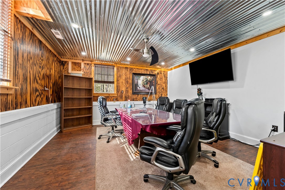 Corrugated metal ceiling, exposed wood-paneled walls, built-in shelving, wood-finish flooring, and recessed lighting