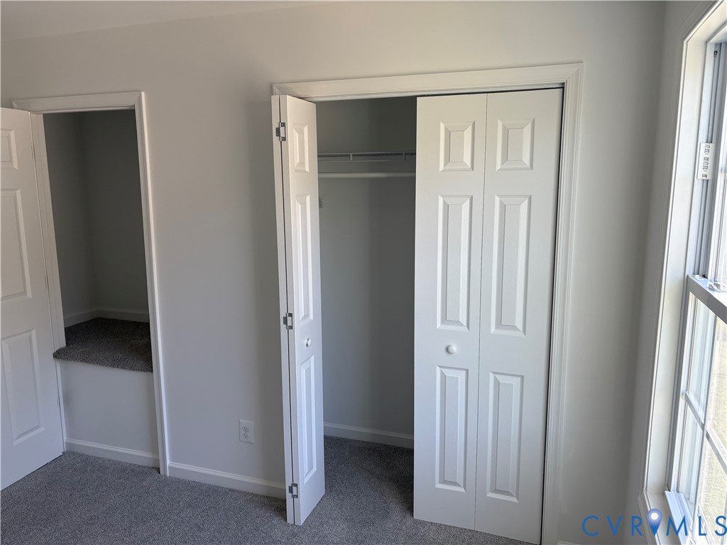 Bedroom 2 Neutral-toned wall-to-wall carpeting, bi-fold closet doors, built-in recessed shelving, and a double-hung window