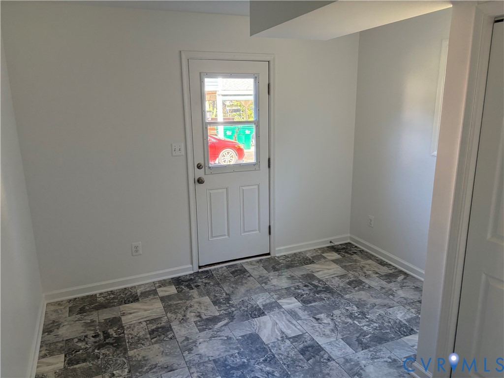 Utility/Laundry Multi-tone patterned tile flooring, neutral wall finishes, and a glass-paneled exterior door