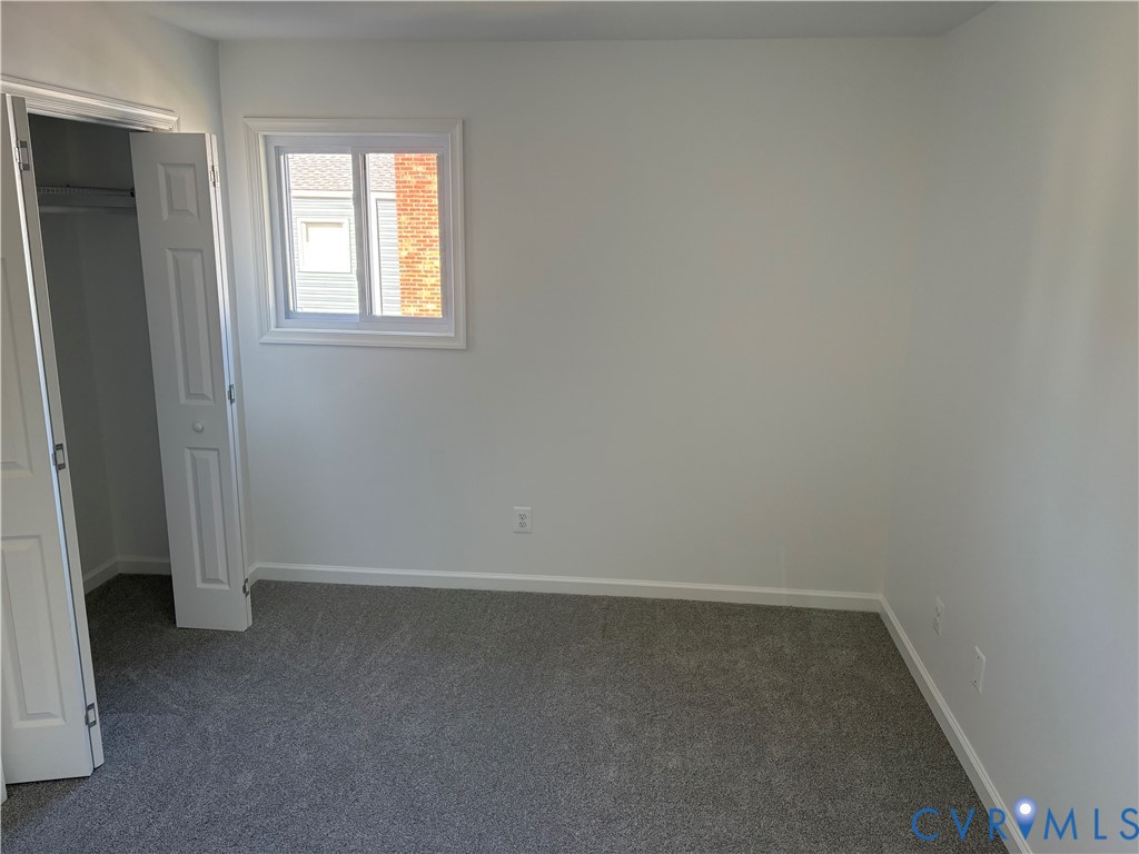 Primary Bedroom Neutral-toned carpeting, single-hung vinyl window, and double-panel closet door