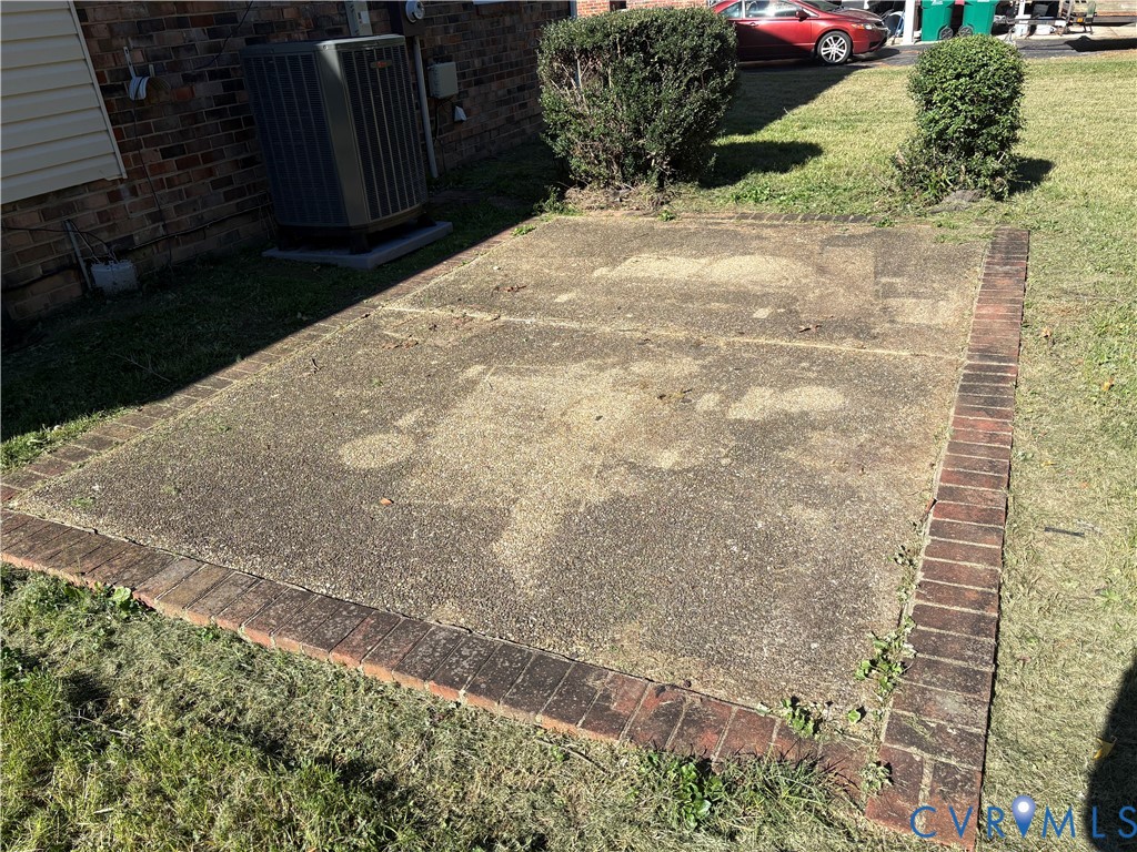 Concrete patio pad framed with decorative brick edging