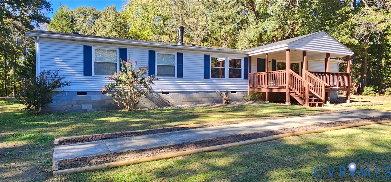 Single-story residence featuring horizontal lap siding, blue shutters, a concrete block foundation, and an elevated wooden deck with stairs