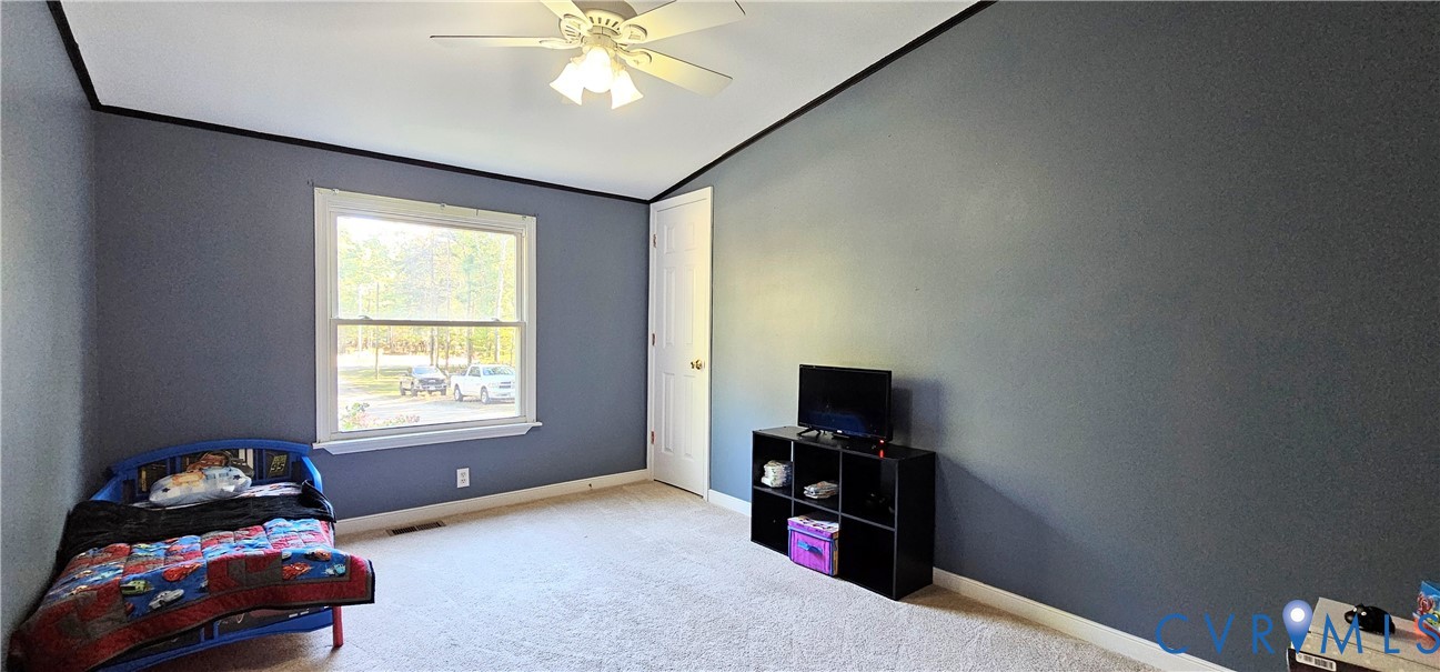 Room featuring a vaulted ceiling, neutral wall-to-wall carpeting, and a multi-light ceiling fan