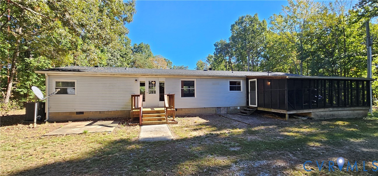 Light gray vinyl siding exterior featuring a screened-in porch, concrete patio, wood-framed stairs, and a multi-pane glass entry door