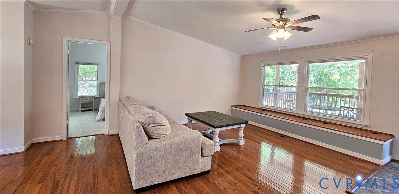 Hardwood flooring, dual windows with integrated bench seating, and a ceiling fan