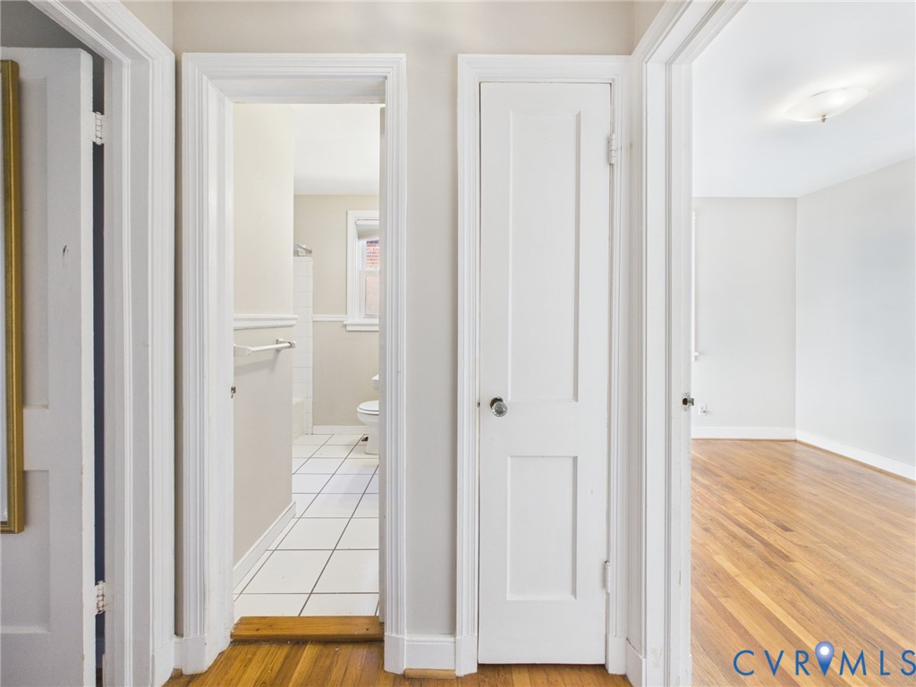 Hallway featuring wood-finish flooring, two-panel interior doors, and a built-in storage closet