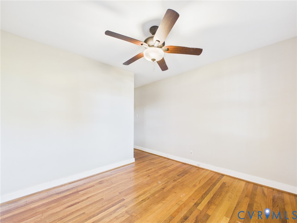 Interior space featuring wood-finish flooring and a ceiling-mounted fan with an integrated light fixture