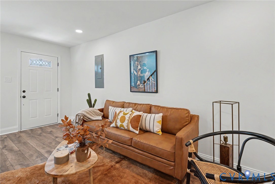 Entryway featuring wood-finish flooring, white walls, and a white exterior door with an inset decorative glass window