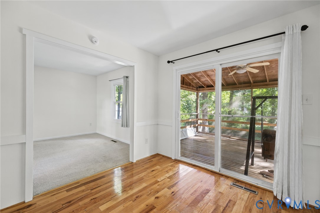 Interior space featuring wood-finish flooring, wainscoting, and sliding glass doors