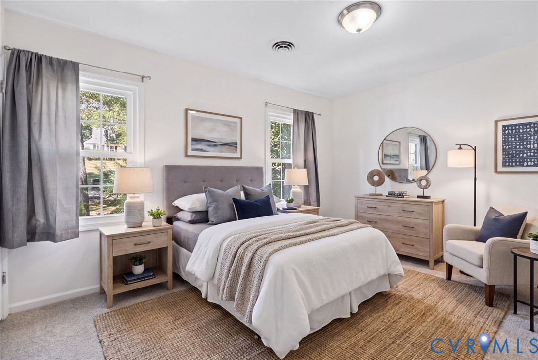 VIRTUALLY STAGED Neutral-toned interior space featuring light wall-to-wall carpeting, multiple windows providing natural light, and a centralized ceiling light fixture