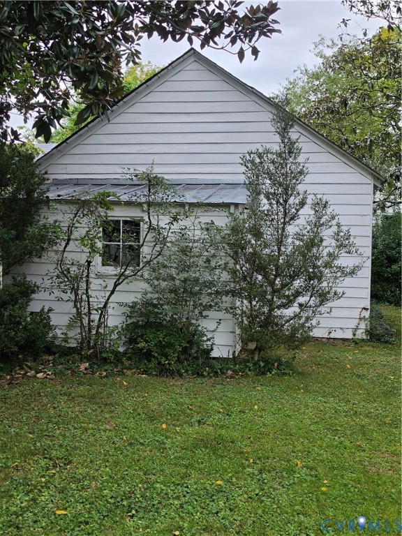 Exterior profile featuring white lap siding, a metal shed roof, and a multi-pane window