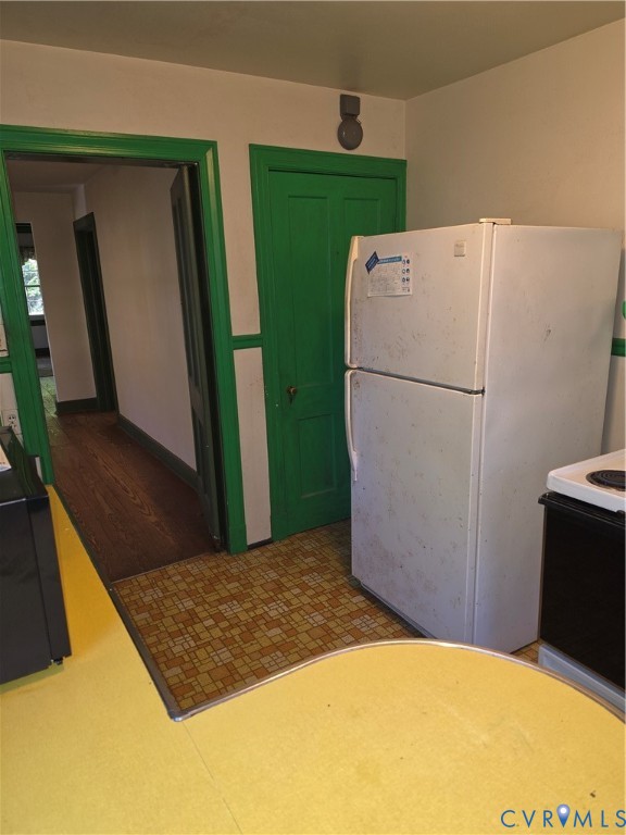 Interior space featuring wood-finish flooring, a solid-core door with prominent trim, and a built-in refrigerator