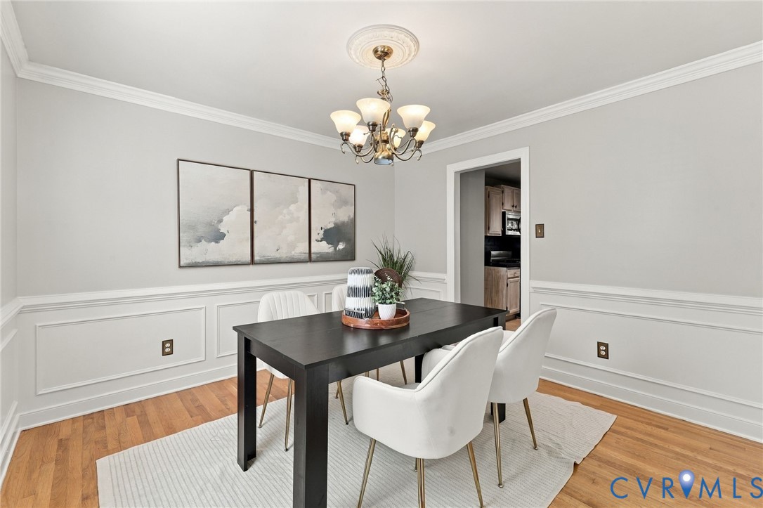 Elegant formal dining room with hardwood flooring, decorative picture molding and crown molding.