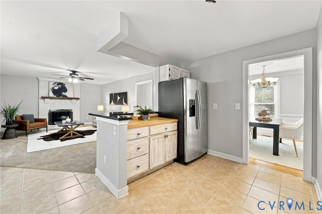 Open kitchen layout overlooking the family room with a brick fireplace, creating a comfortable space for everyday living and entertaining.