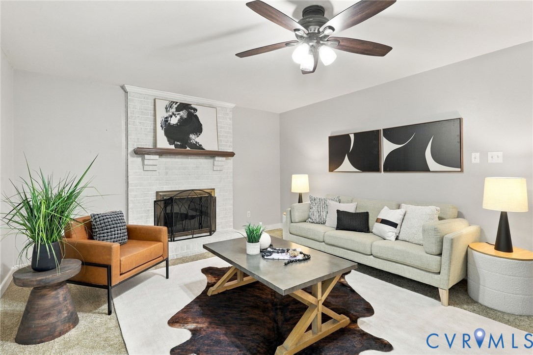 Inviting family room featuring a whitewashed brick fireplace, wood mantel, and ceiling fan.