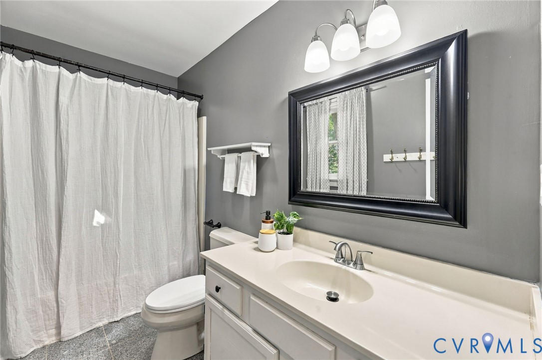 Full hall bathroom featuring a spacious vanity, tub/shower combination, and updated light fixture.